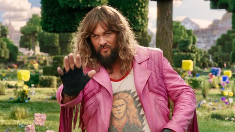 man in pink jacket holding his hand up