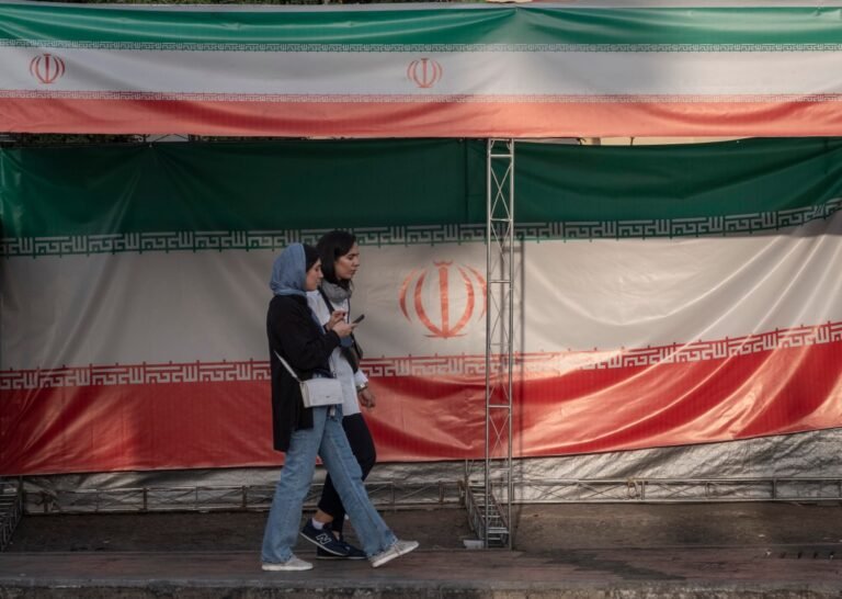 Apple alerted Iranians to iPhone spyware attacks, say researchers Two young Iranian women walk past the country's flags in northern Tehran, Iran, on June 30, 2025, following the ceasefire between Iran and Israel.