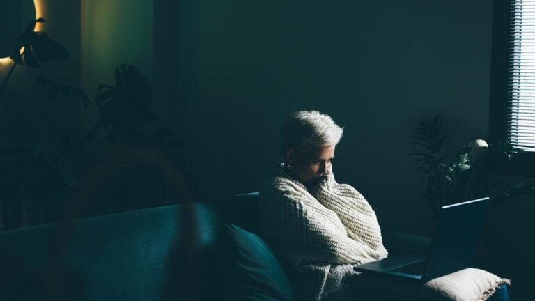 Sad woman using laptop at home