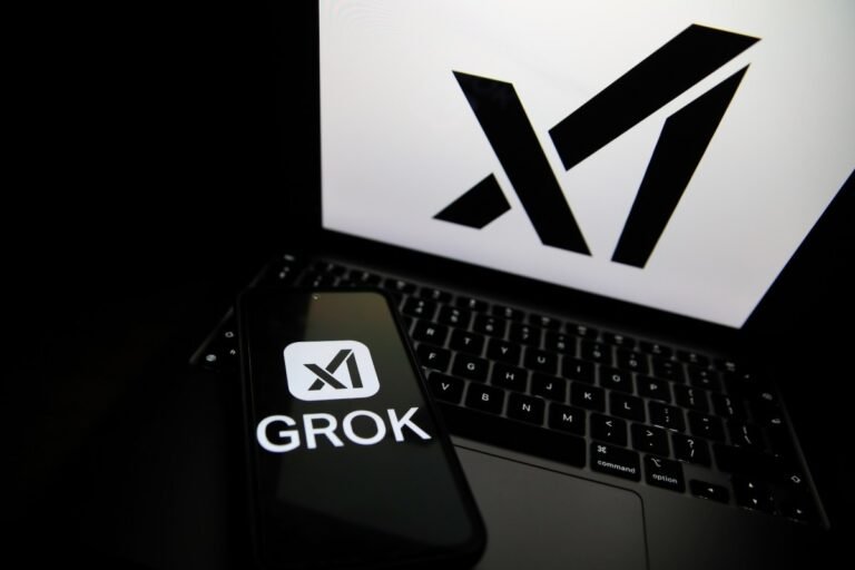 xAI reportedly lays off 500 workers from data annotation team The Grok logo appears on a phone and the xAI logo is displayed on a laptop.