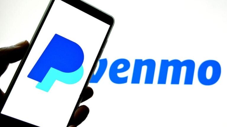 Before You Use Venmo and PayPal’s New Transfer Feature, Change This Setting A phone with a PayPal "P" logo held in front of a blue Venmo logo.