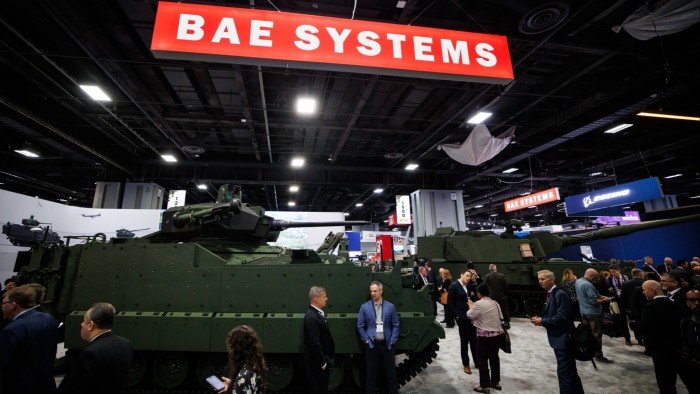 Costigan cashes in on BAE’s defensive qualities A Bradley Fighting Vehicle and a CV90120 armoured vehicle displayed at the BAE Systems booth, surrounded by attendees at a defence show.