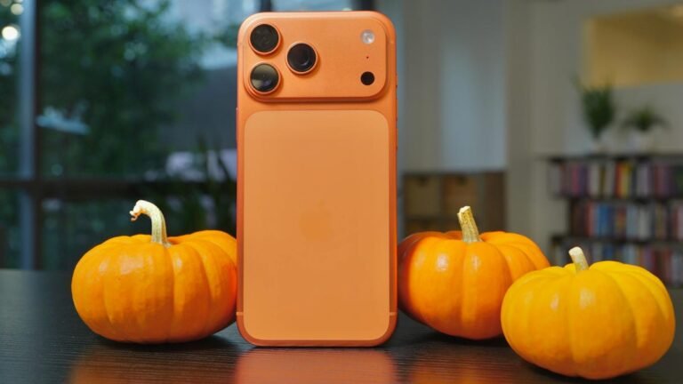 An iPhone 17 Pro Max in cosmic orange next to pumpkins