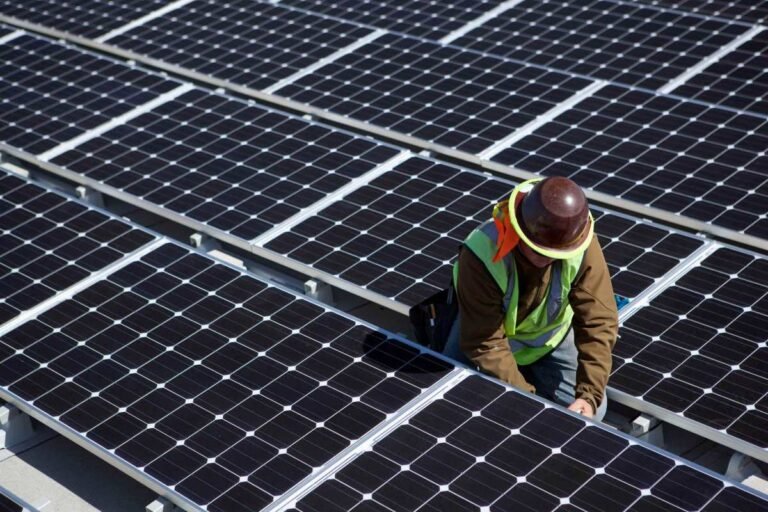 A man inspects solar panels.
