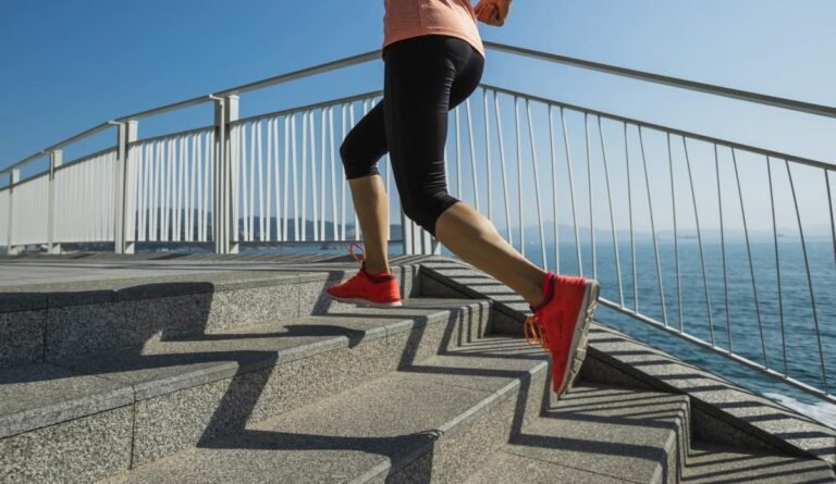 A person runs up stairs near the ocean.