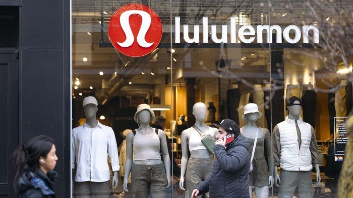 Lululemon shares jump after chief Calvin McDonald announces departure Storefront of a Lululemon shop with mannequins dressed in athletic wear and two people walking past outside.